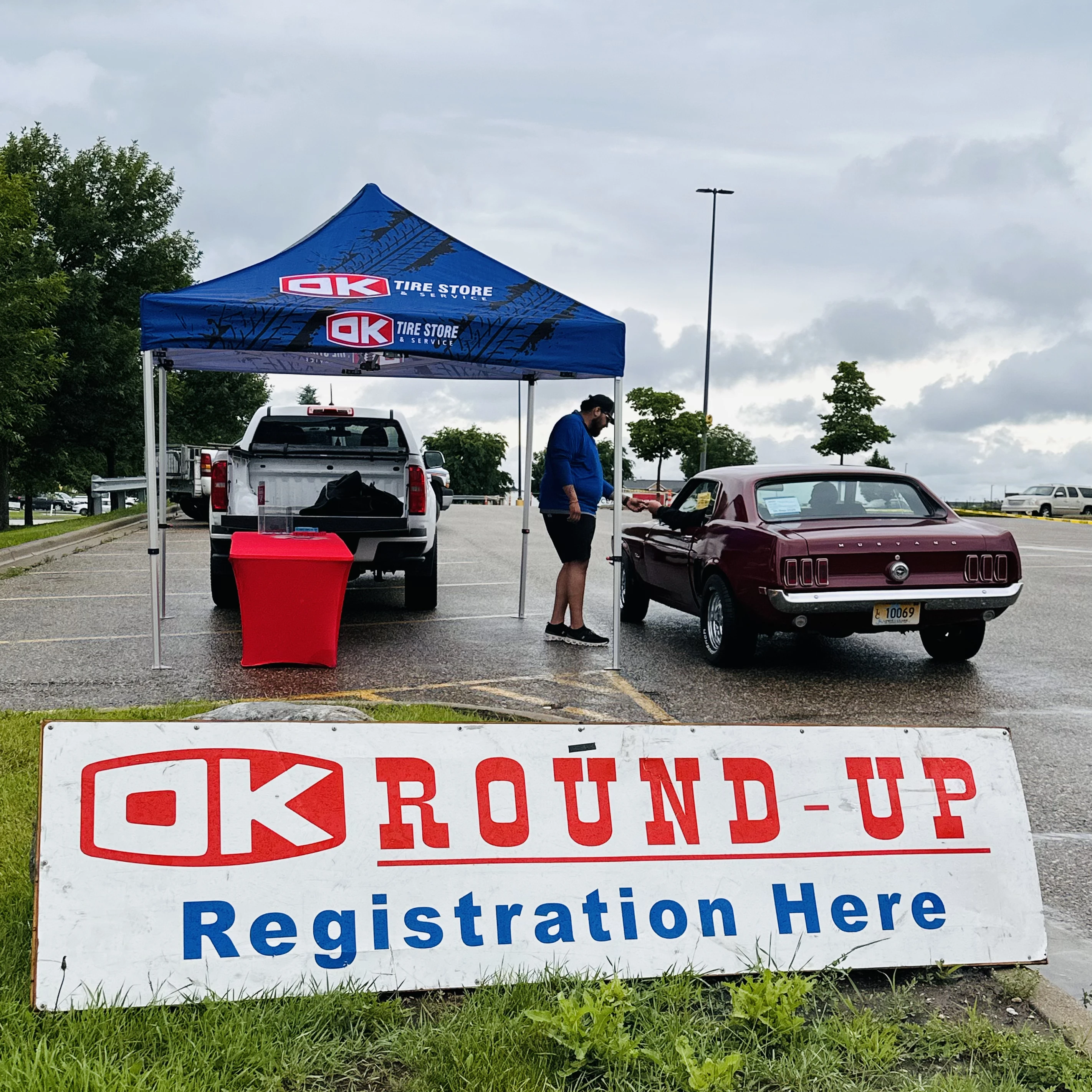 OK Tire Round Up registration tent with a classic Mustang pulling up