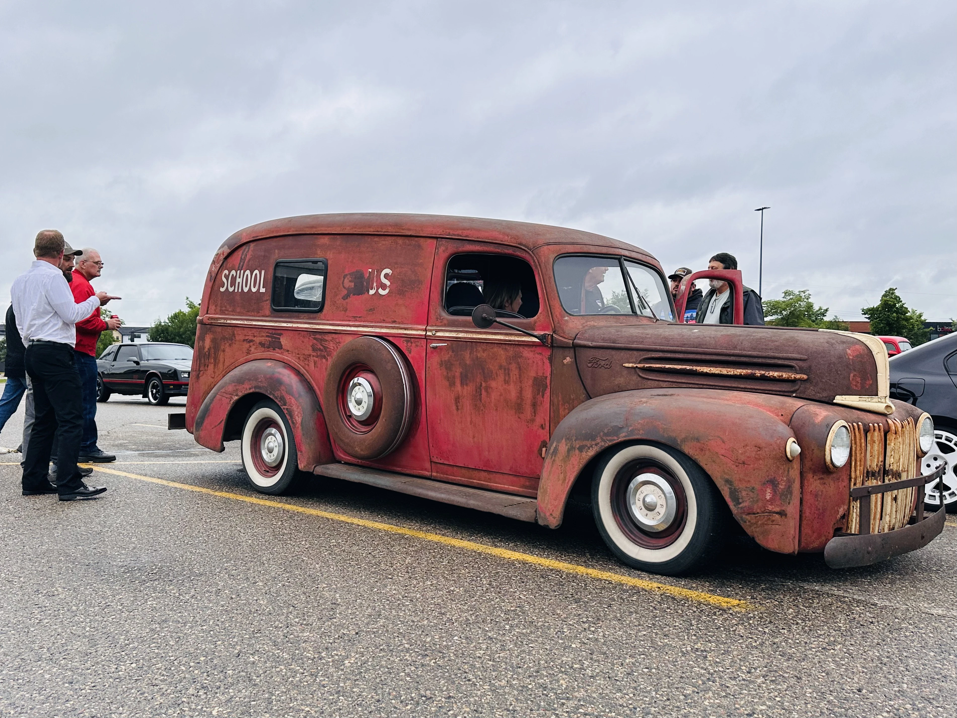 Patina red vintage school bus rat rod on display at the car show